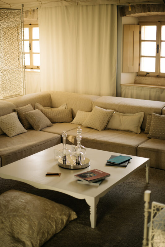 Cozy living area in Lešić Dimitri Palace featuring a beige sectional sofa, a coffee table with decorative items, and books.