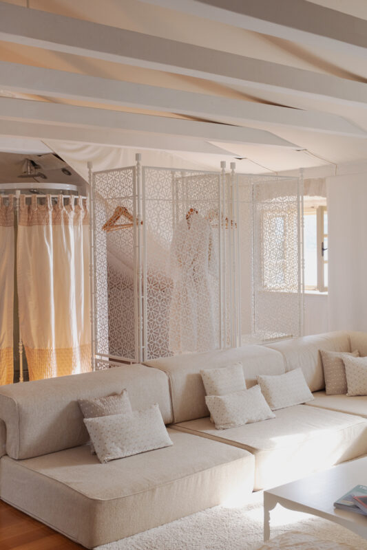 Brightly lit interior of Lešić Dimitri Palace featuring a cozy sofa, decorative privacy screens, and light curtains.