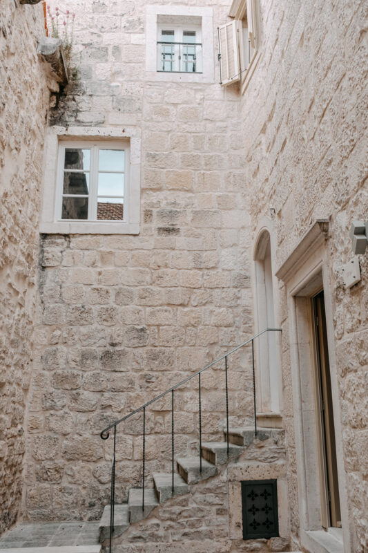 Stone staircase leading up to windows in a narrow alley at Lešić Dimitri Palace.