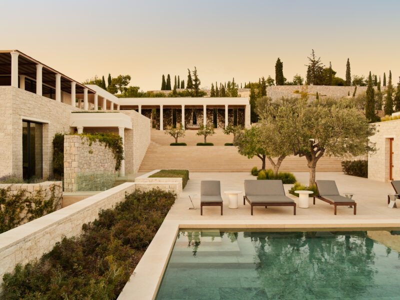 Villa 22 at Amanzoe, Greece, featuring a serene pool area, sun loungers, olive trees, and landscaped terraces.