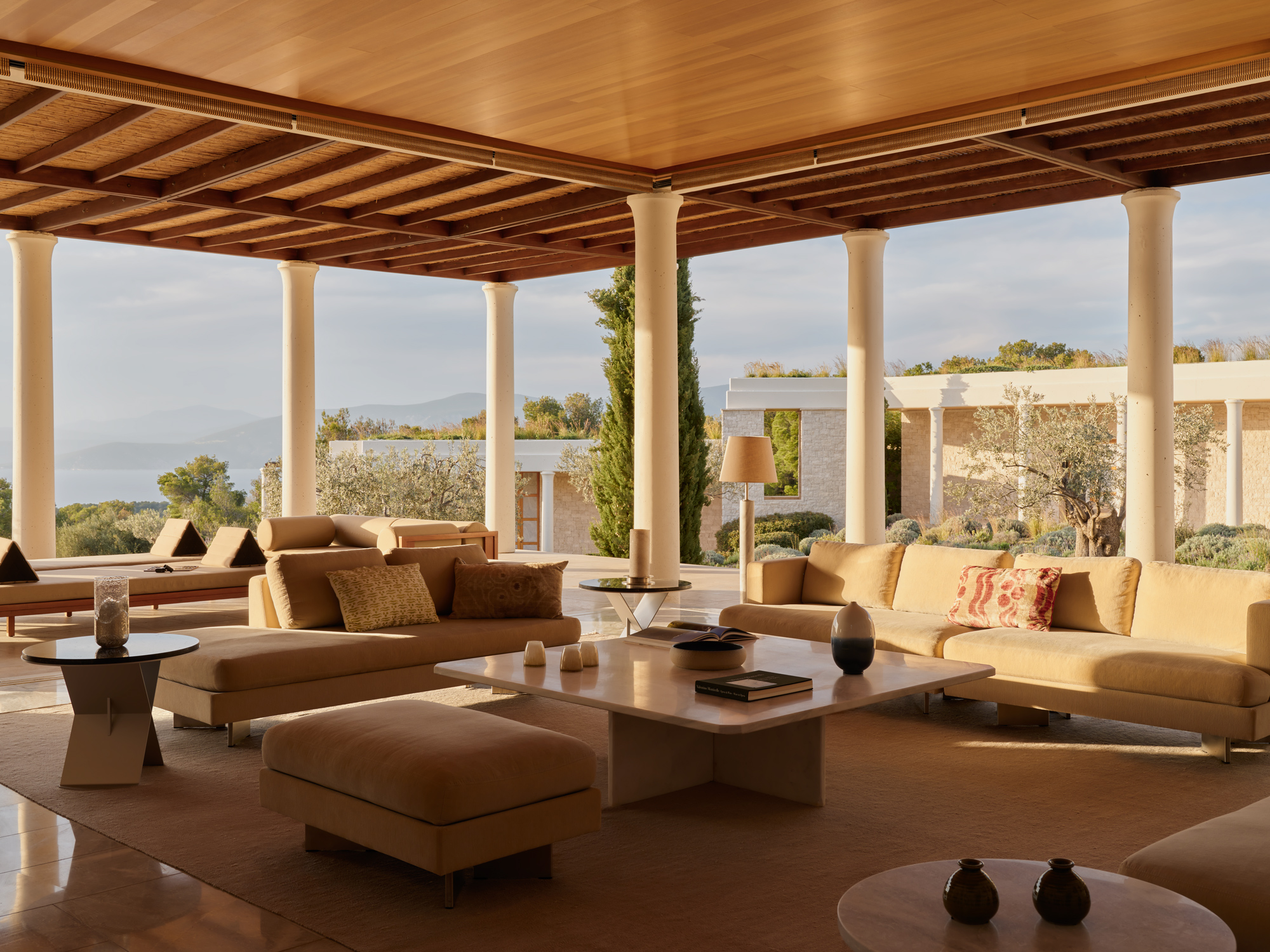 Spacious living area in Villa 3 at Amanzoe, featuring modern furniture, large windows, and scenic outdoor views.