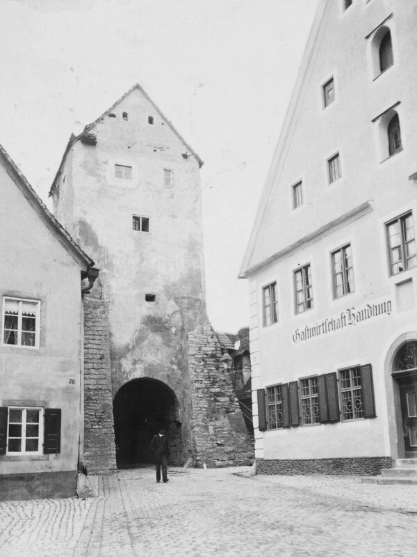 Historic black-and-white photo of Gredinger Tor in Berching, featuring a stone tower and nearby buildings.