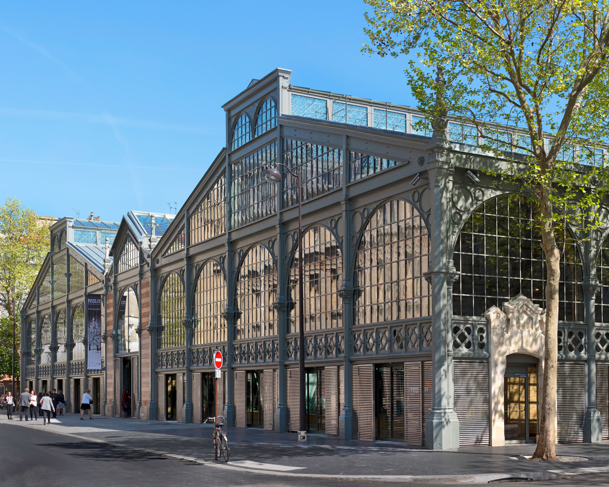 Historic Carreau du Temple building in Paris, showcasing its glass facade and architectural details on a clear day.