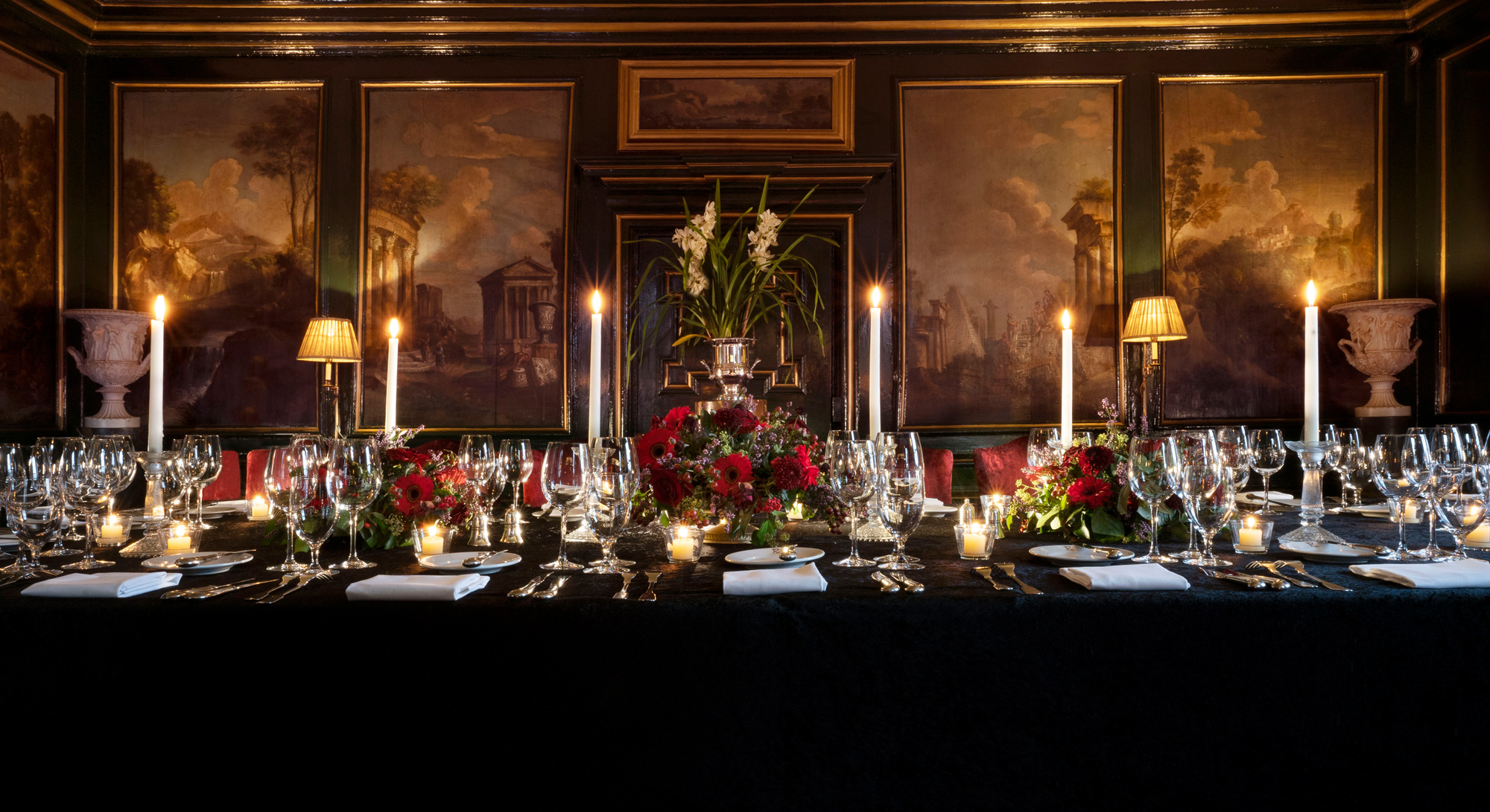 Elegant dining setup in the Italian Room at Prestonfield House, featuring floral centerpieces and candlelight.