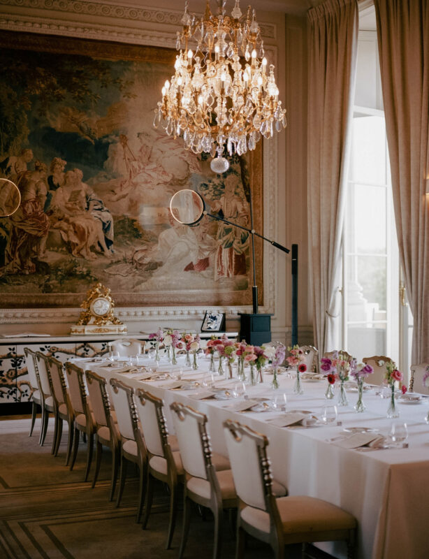 Elegant dining room at Hôtel de Crillon, featuring a long table set with floral arrangements and a chandelier.