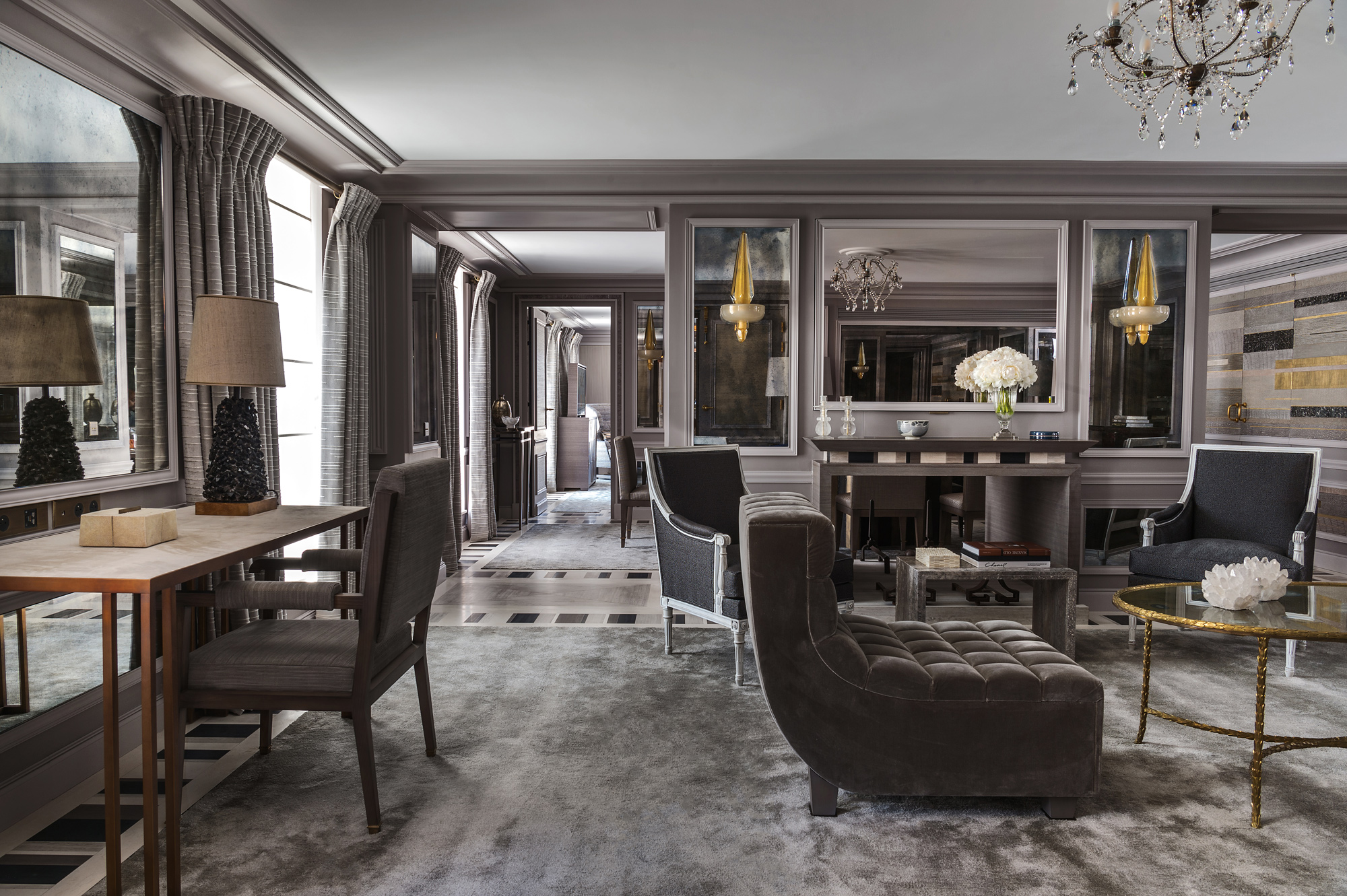 Elegant living room in Hôtel de Crillon featuring plush seating, a chandelier, and stylish decor in muted tones.