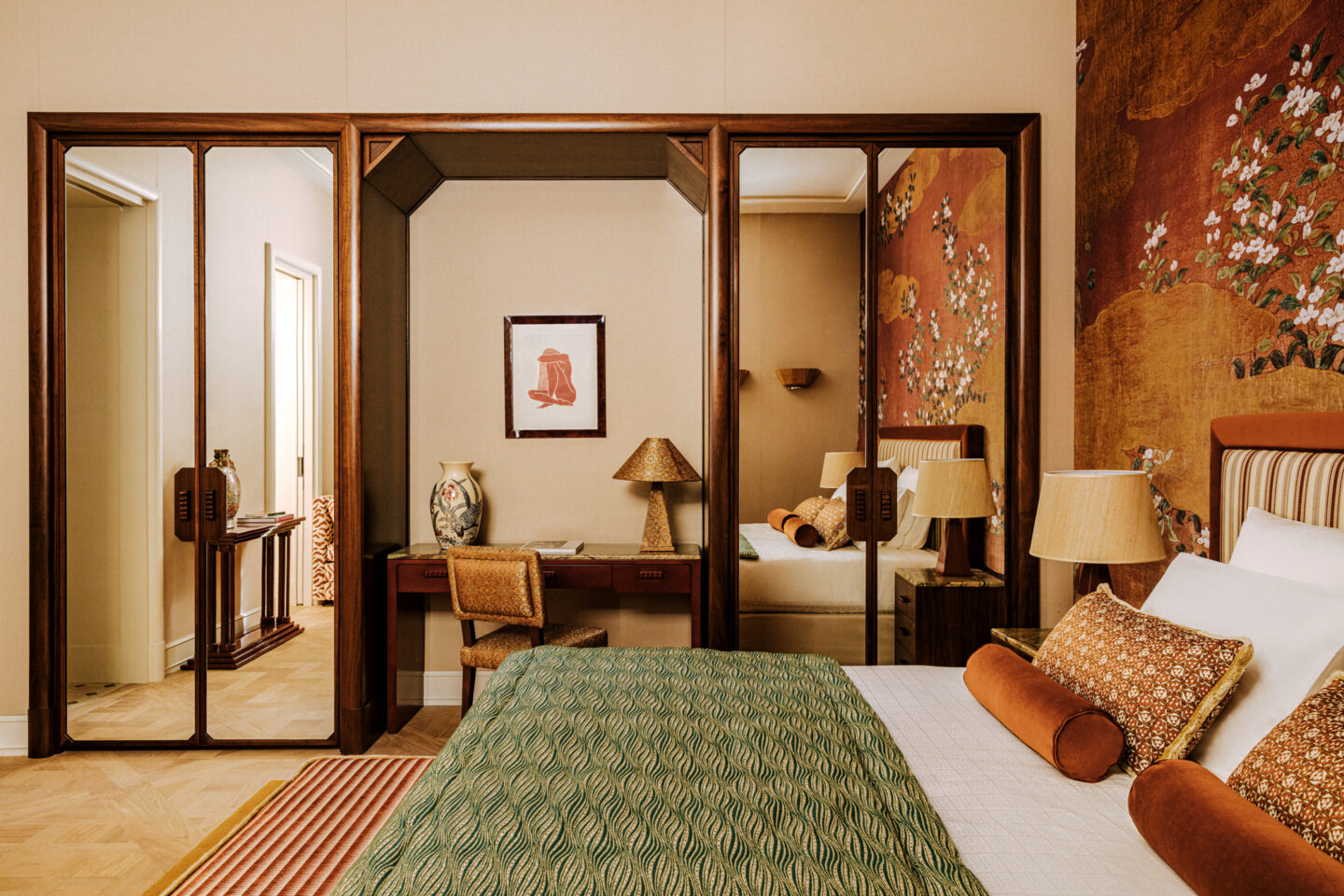 Luxurious hotel suite at Saint James Paris, featuring elegant decor, a desk, and floral wallpaper.
