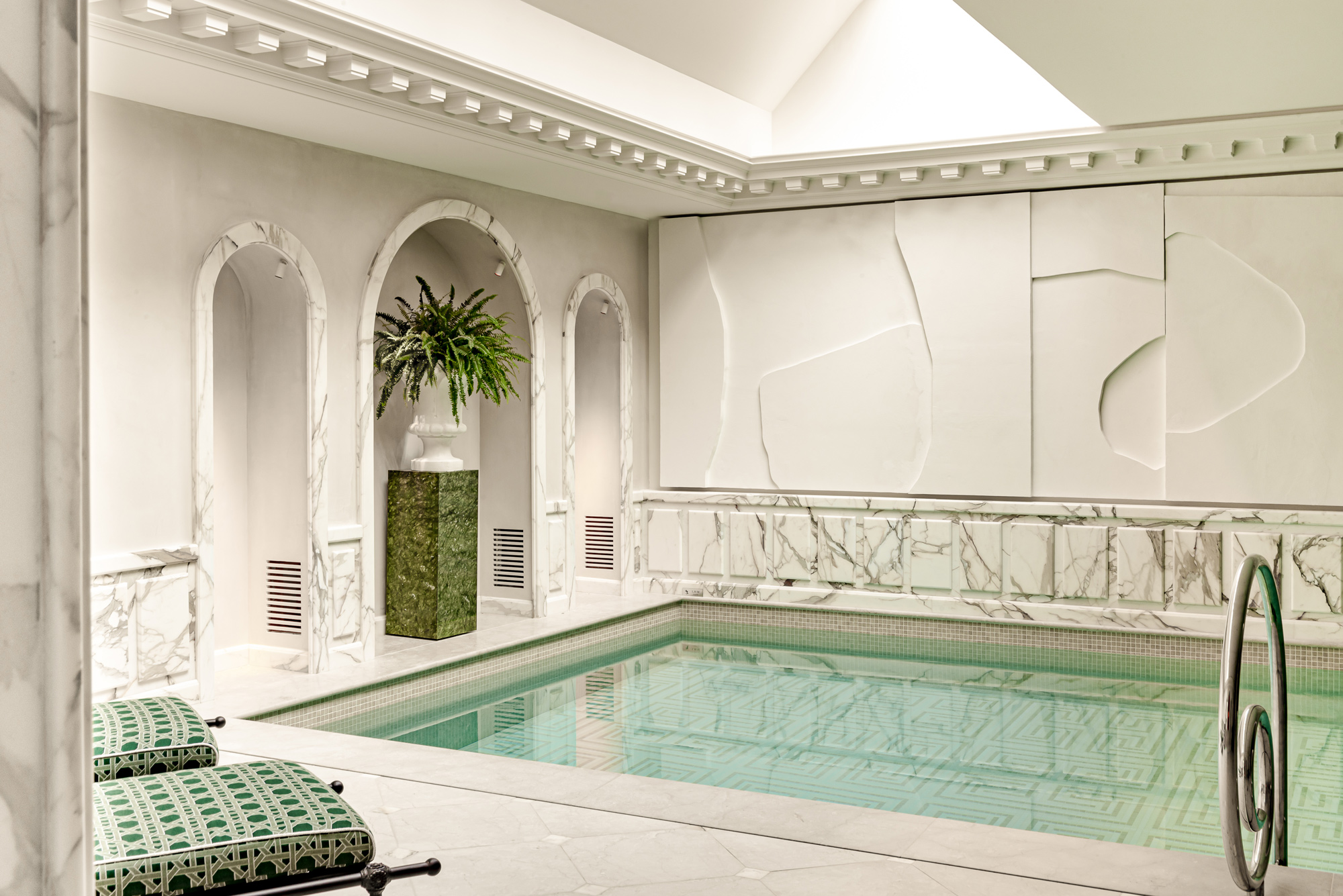 Wellness area at Saint James Paris featuring a marble pool, green accents, and elegant architectural details.