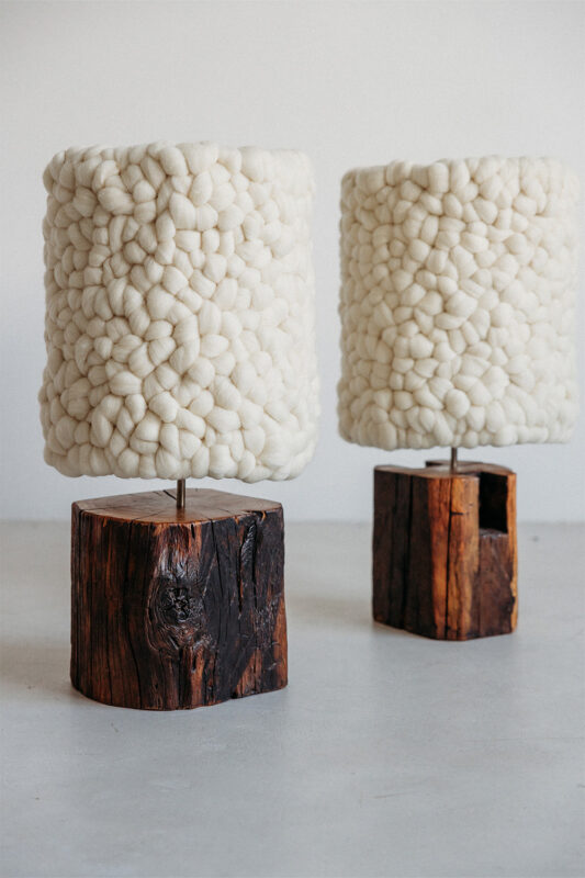 Two textured lamps with fluffy white shades atop rustic wooden bases.