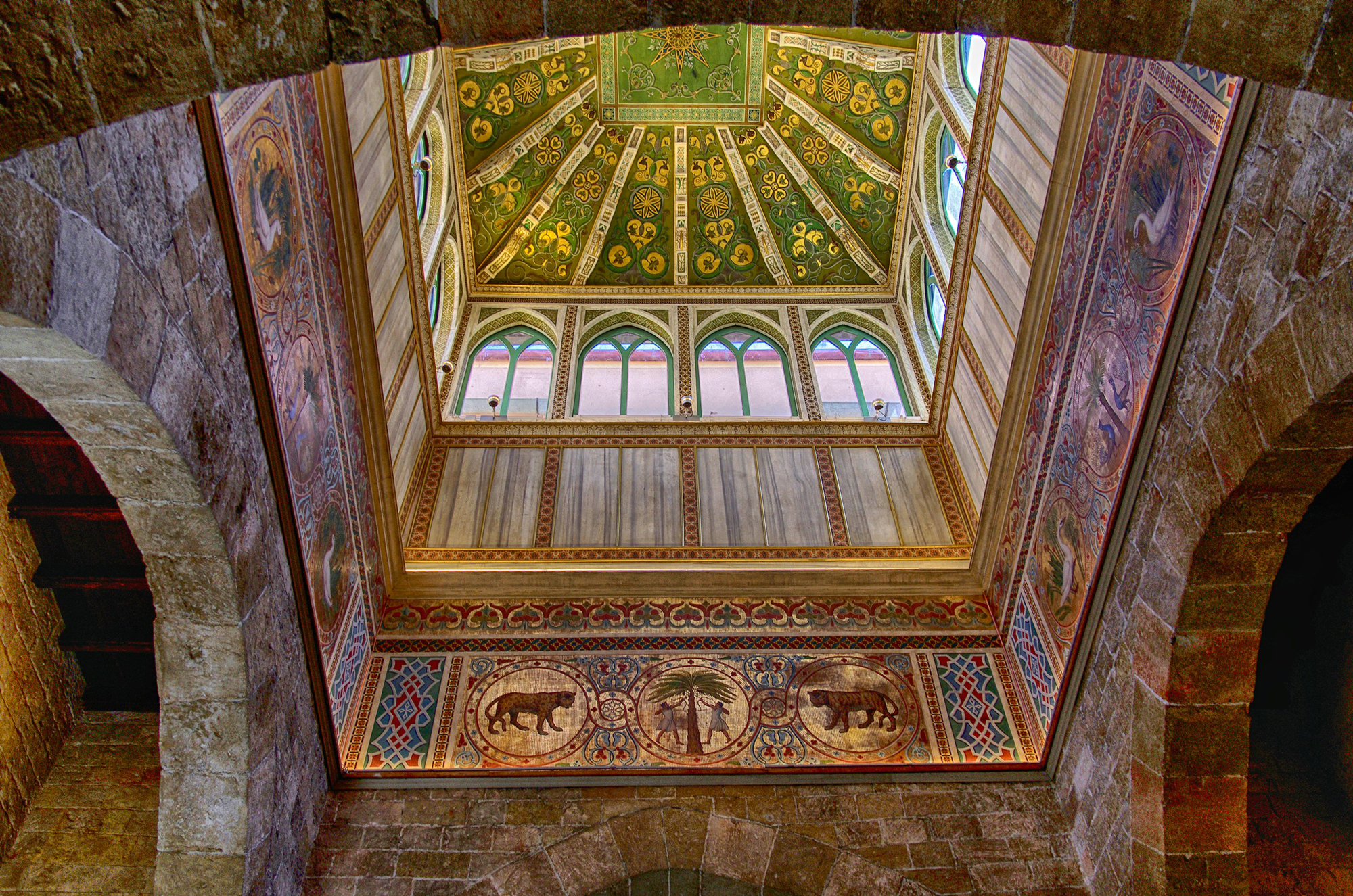 Intricate ceiling with floral patterns and arches, featuring painted animals and decorative motifs in Palermo.
