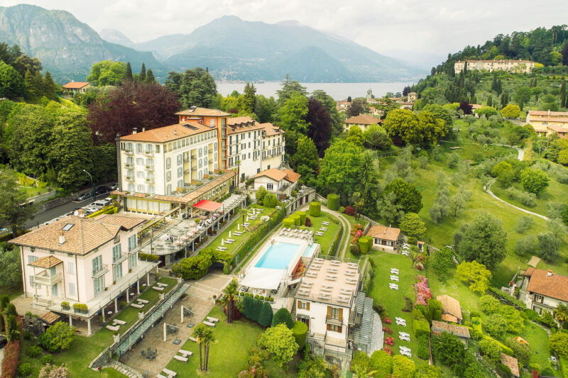 Aerial view of Belvedere Bellagio hotel with gardens, pool, and surrounding mountains near Lake Como.